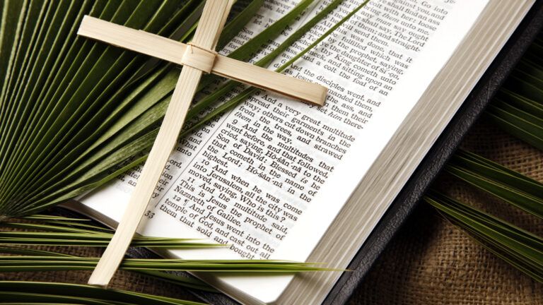 Palm cross on an open Bible showing how to celebrate lent