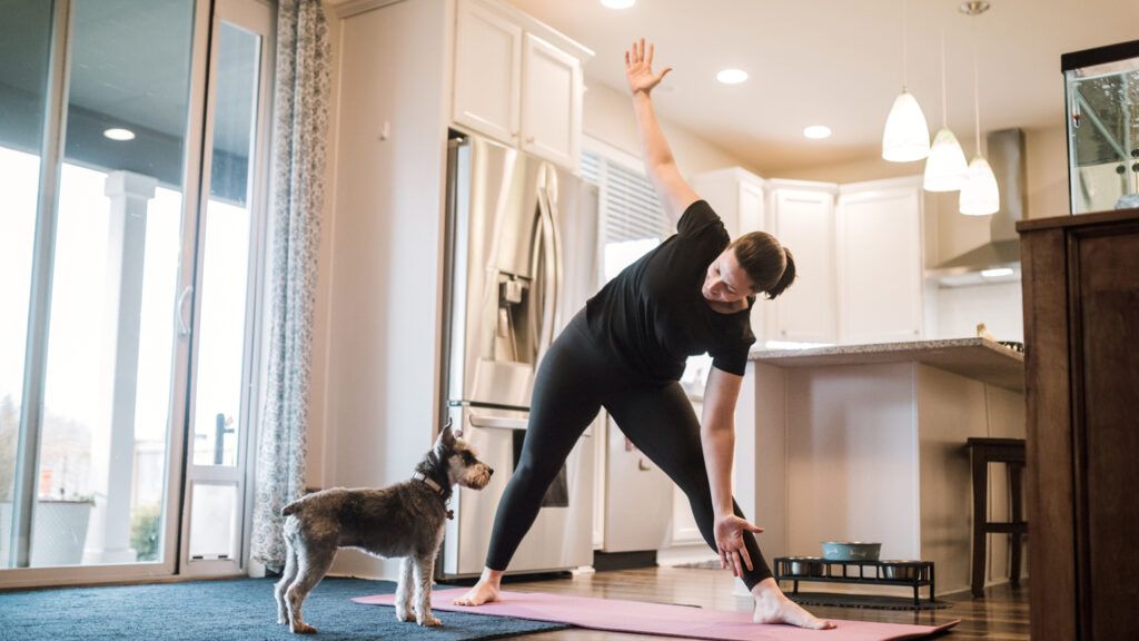 A woman exercising with her dog; Getty Images