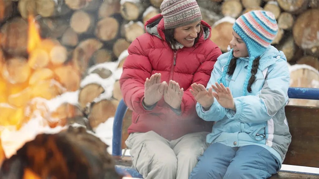 Mother and daughter enjoying a backyard fire pit; Getty Images