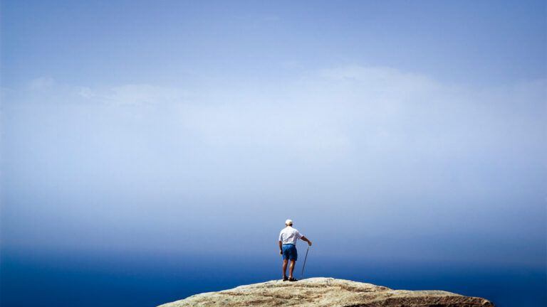 Senior man standing on a rock