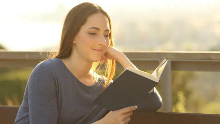 A woman reading outside; Getty Images