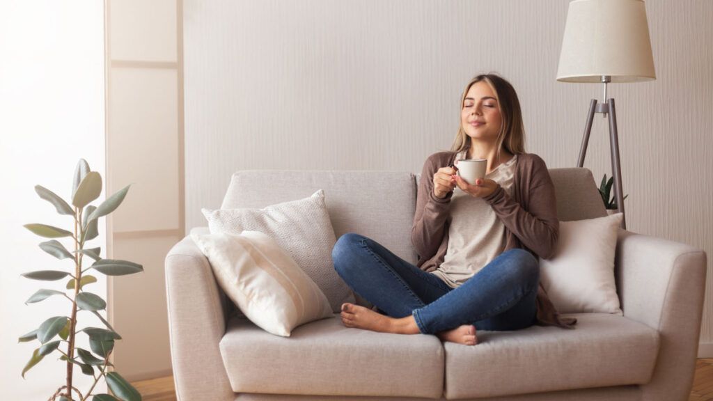 A woman finding peace on her couch; Getty Images