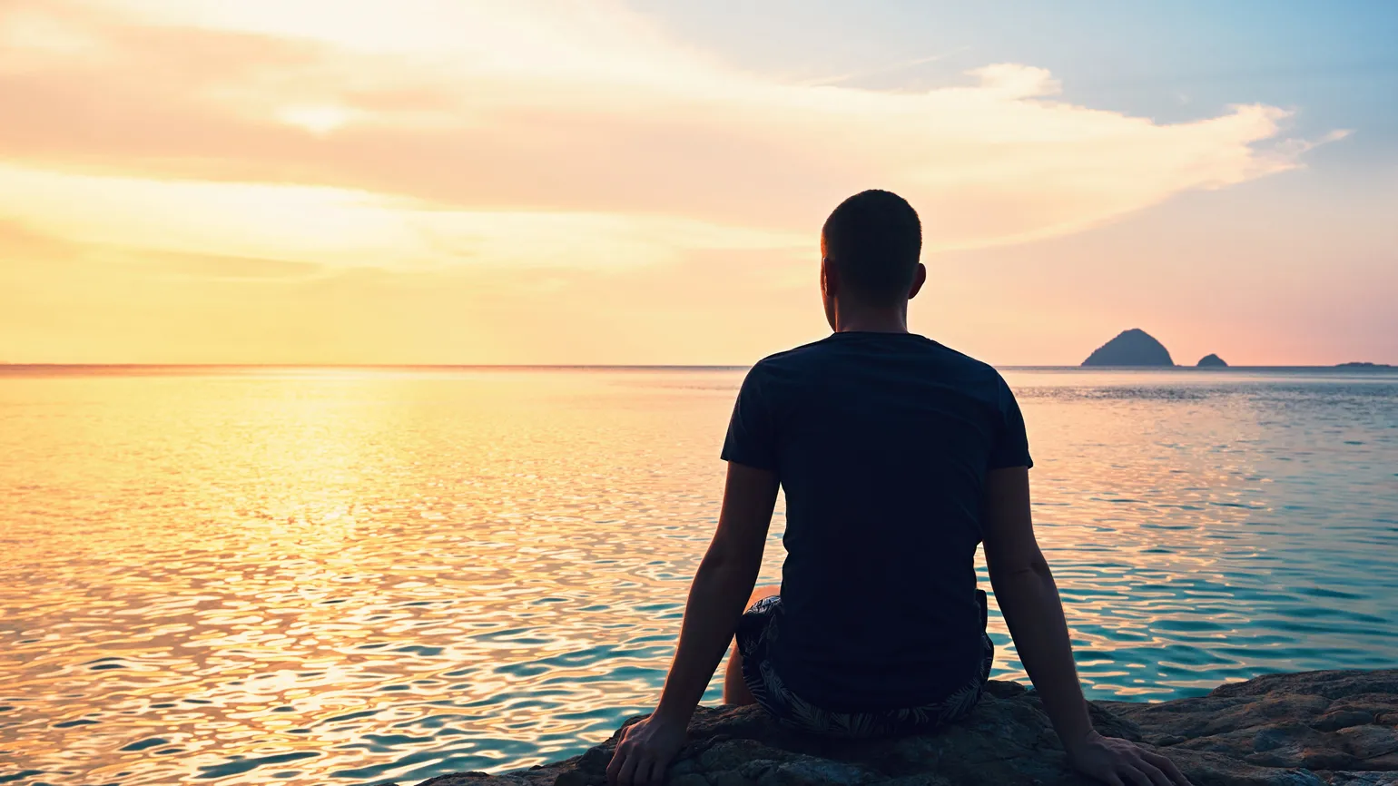 Man looking over the ocean; Getty Images