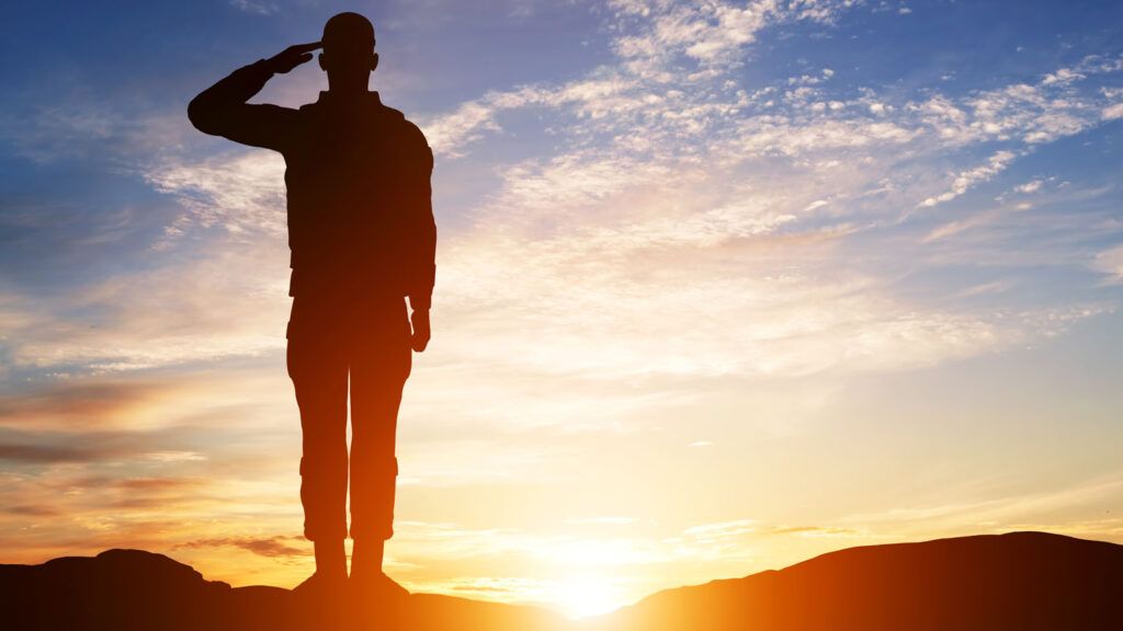 Soldier salute silhouette with sunset sky; Getty Images
