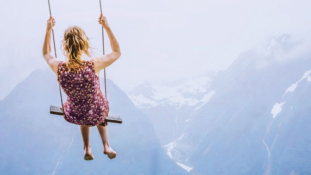 A woman on a swing in the mountains; Credit: Anna Berkut/Getty Images