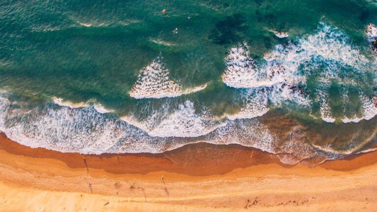 An aerial view of waves lapping on a beach