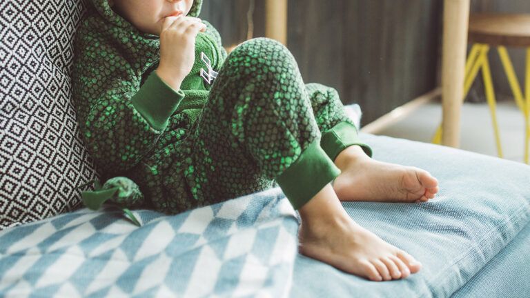 A young boy in dinosaur pajamas; Getty Images