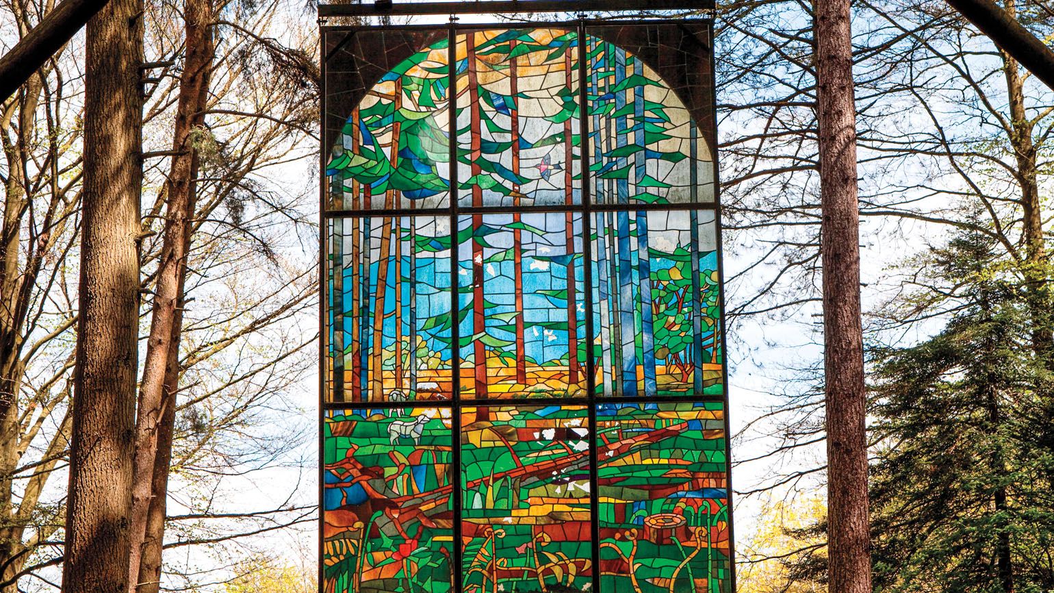 Cathedral’ by Kevin Atherton, is a suspended stained glass panel in the Gloucestershire Forest of Dean Sculpture Park. Credit: Neil McAllister/Alamy