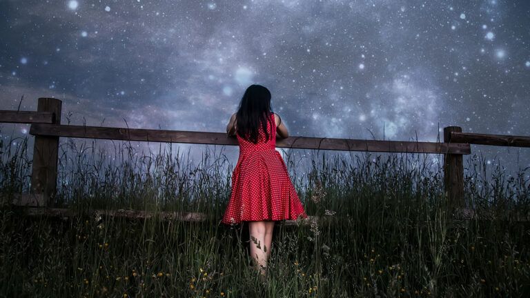 A yound girl gazes at a star-filled sky