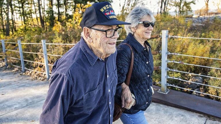 WWII military war veteran father and daughter walking; Getty Images