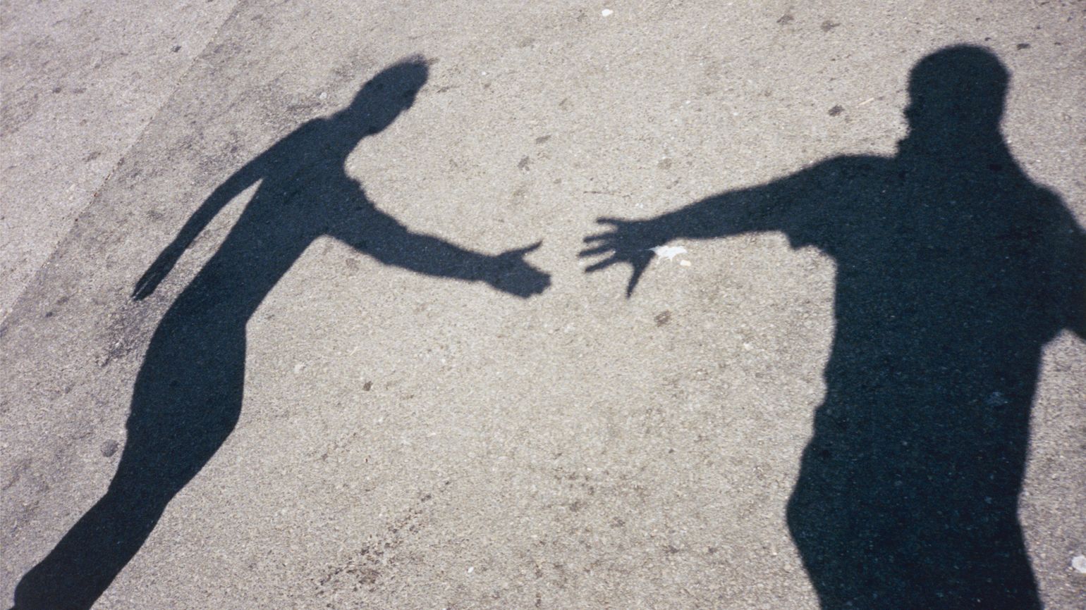 Two shadows reaching for each other; Getty Images