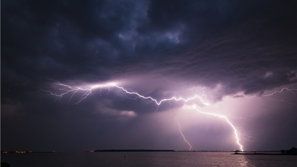 A bolt of lighning over a body of water; Getty Images