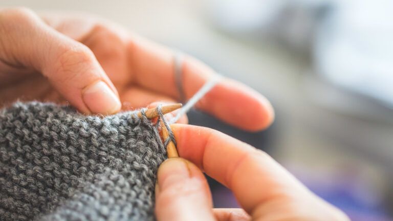 Close up of fingers knitting at home (Getty Images)