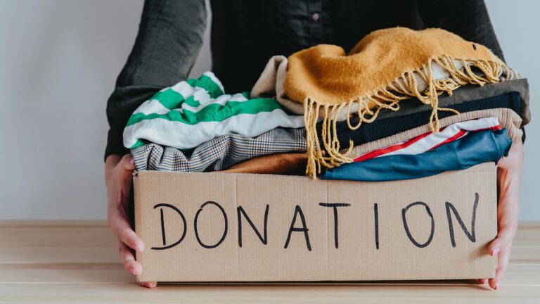 A woman gathers clothes to donate to charity