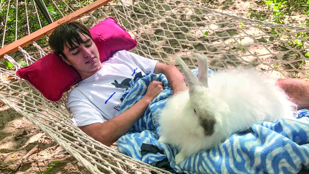 Caleb Smith relaxing on a hammock with a bunny