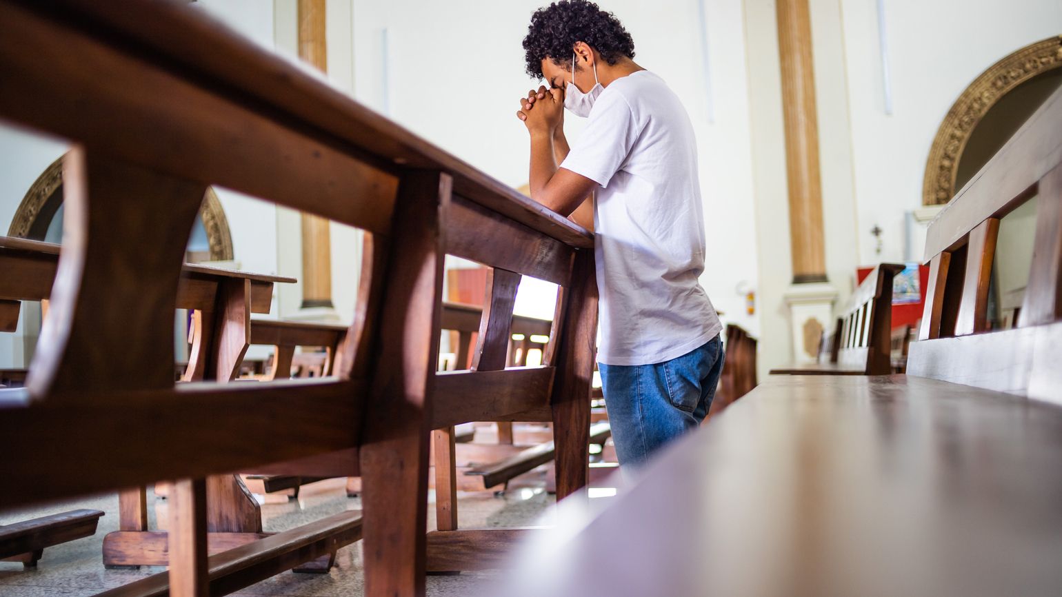 A man praying in church; Getty Images