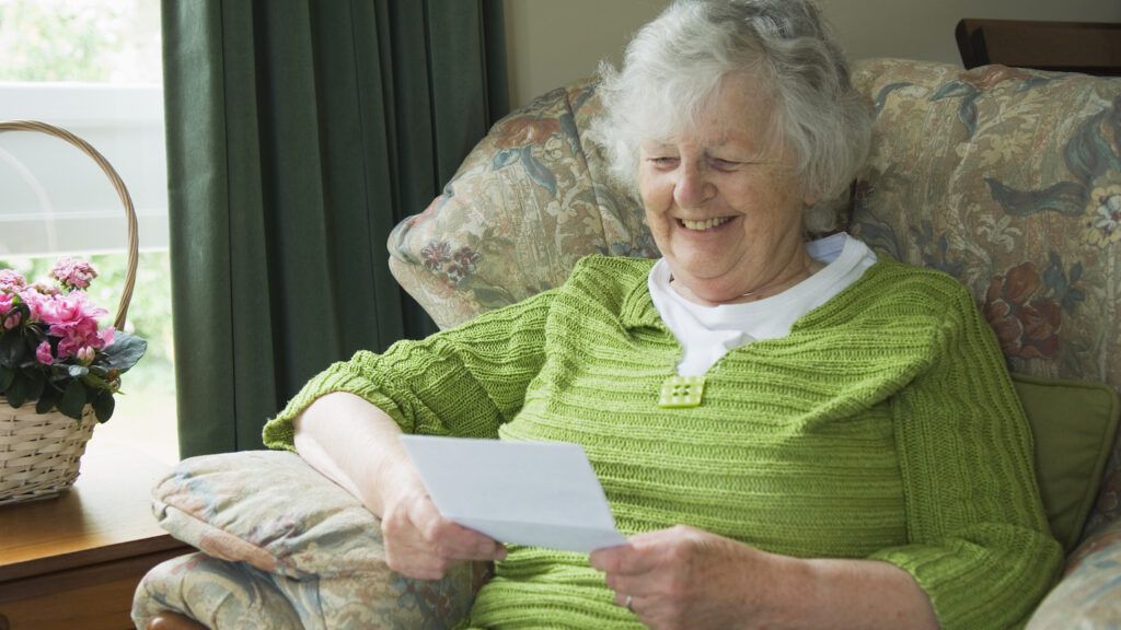 A senior woman reads a letter.