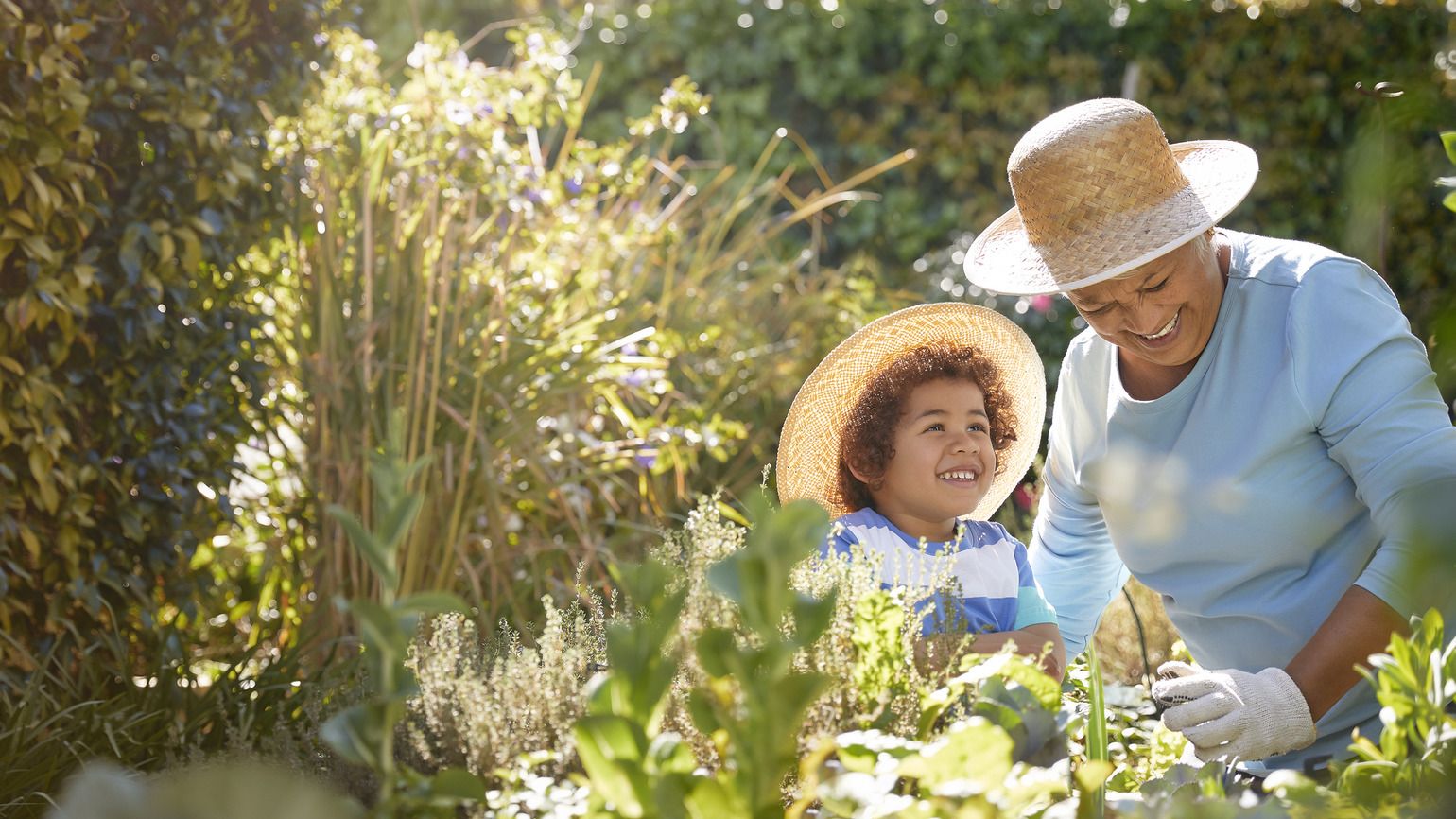 Grandmother and child gardening outdoors (Getty Images)