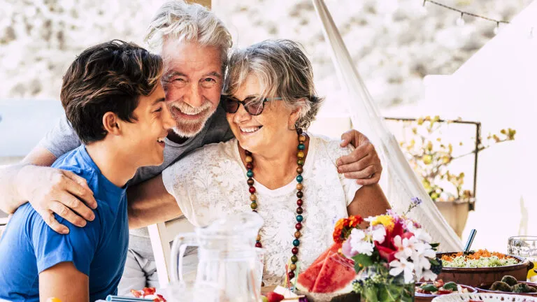 Grandparents hugging their teenage grandchild