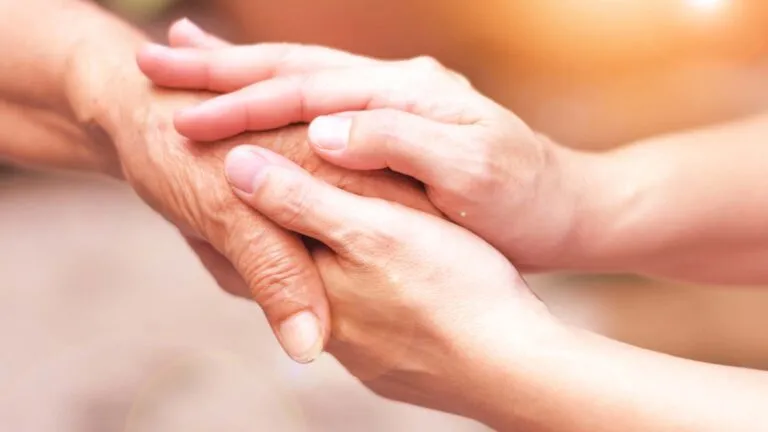 A pair of hands holding each other; Getty Images