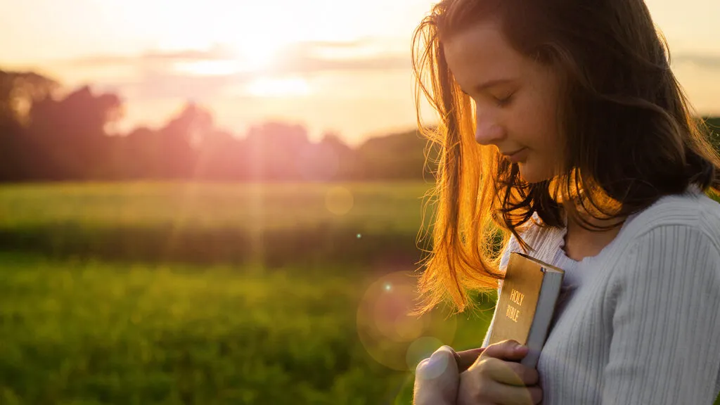 A woman greets the sunrise with a prayer