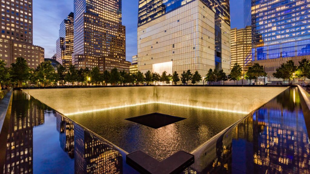 The North Reflecting Pool illuminated at twilight with view of One World Trade Center. Lower Manhattan, 911 Memorial & Museum, New York City (Alamy)