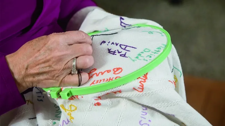 Deb embroidering her Thanksgiving tablecloth