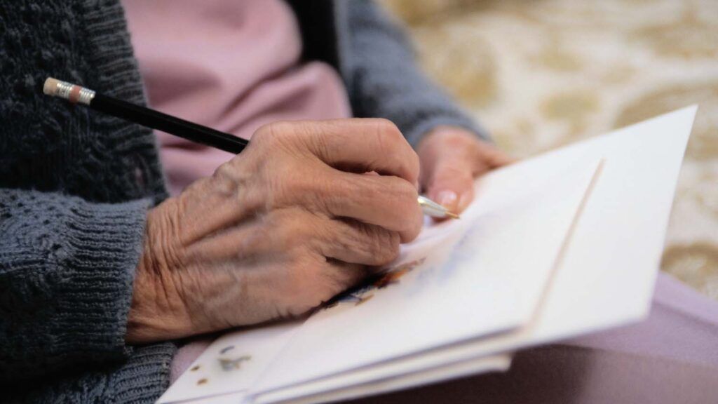 Senior citizen writing a letter; Getty Images