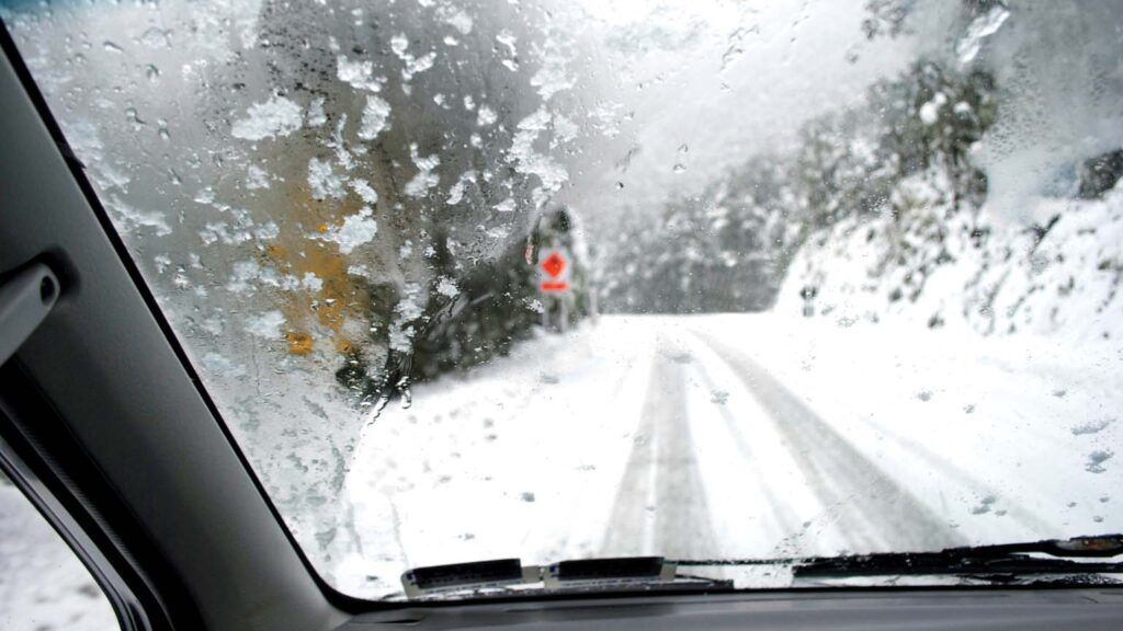 A snowy road from a car's dashboard view; Getty Images/iStock Photo