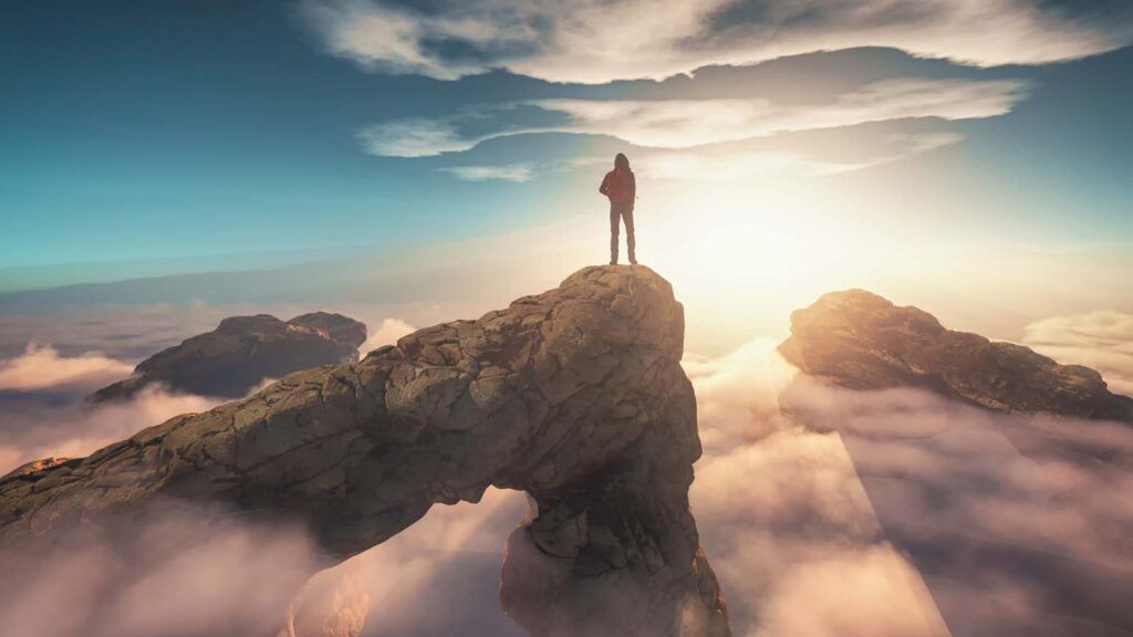 Traveler standing on a mountain peak; Getty Images