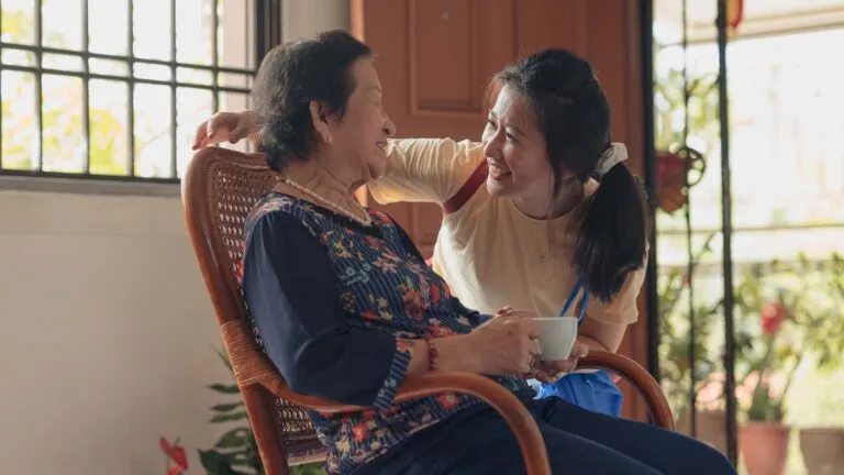 Home caregiver assiting her patient; Getty Images