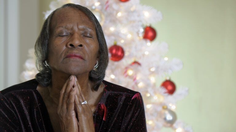 A woman prays at Christmas