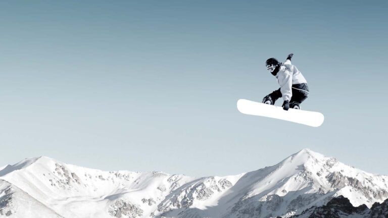 A snowboarder making a high jump in clear, blue sky; Getty Images