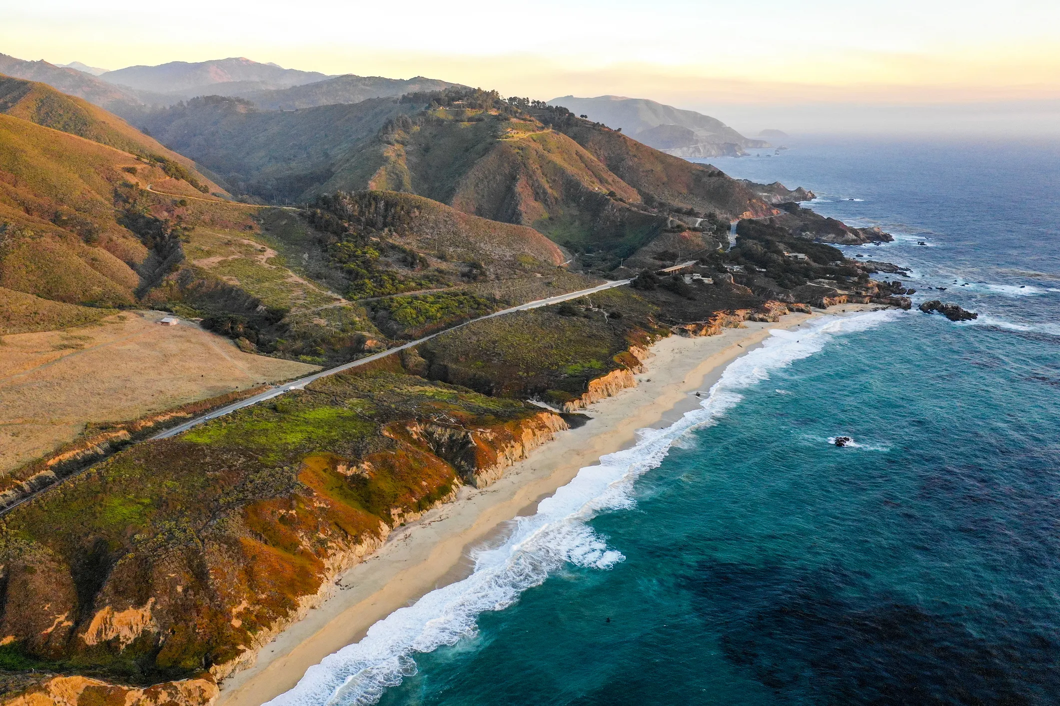 A beach near the mountains show the work of God's hands