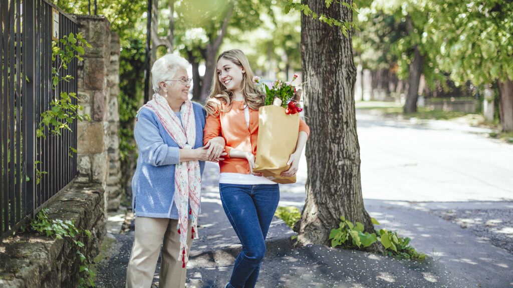 Young woman helping elderly woman with groceries