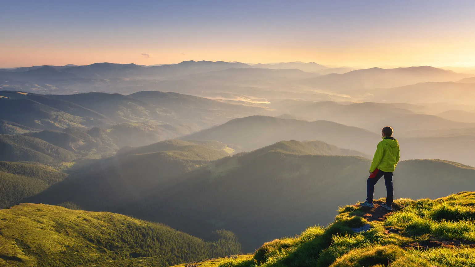 A man thinking about God's hands while looking out at a mountain landscape