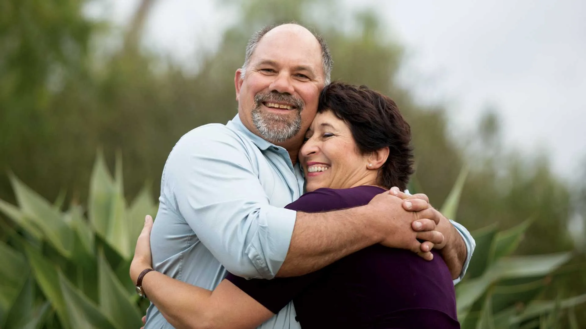 A smiling couple hugs each other in their true love story