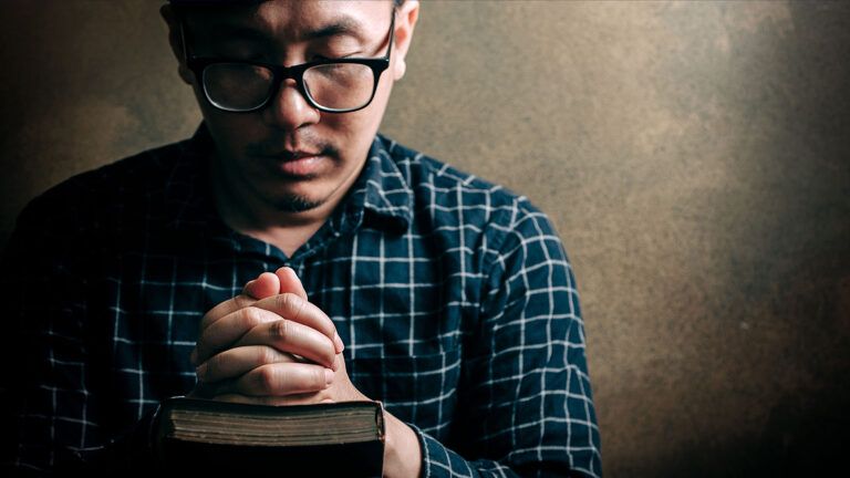 A man prays over his Bible