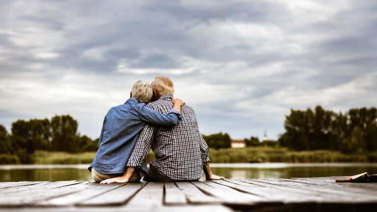Senior couple in an embrace on a dock
