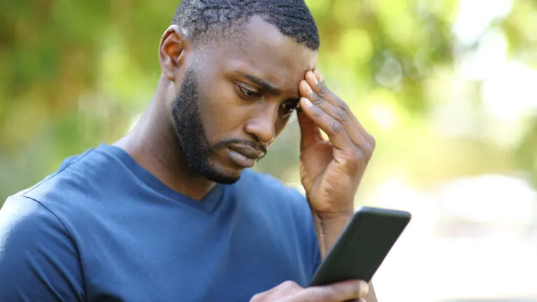 Man doomscrolling on his phone while at the park