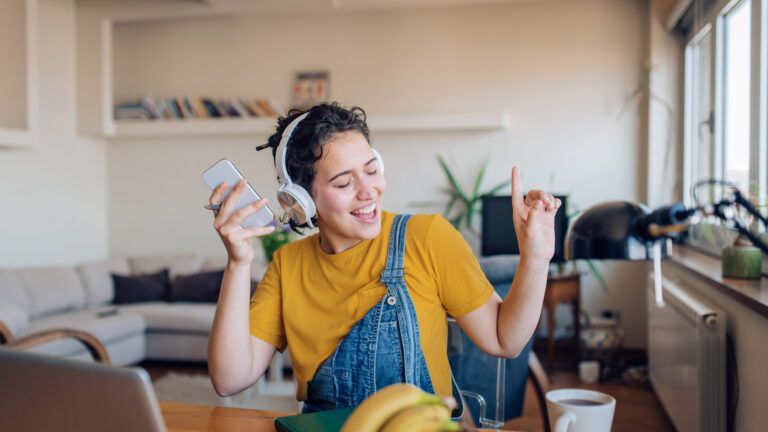 Woman singing and listening to music to avoid doomscrolling