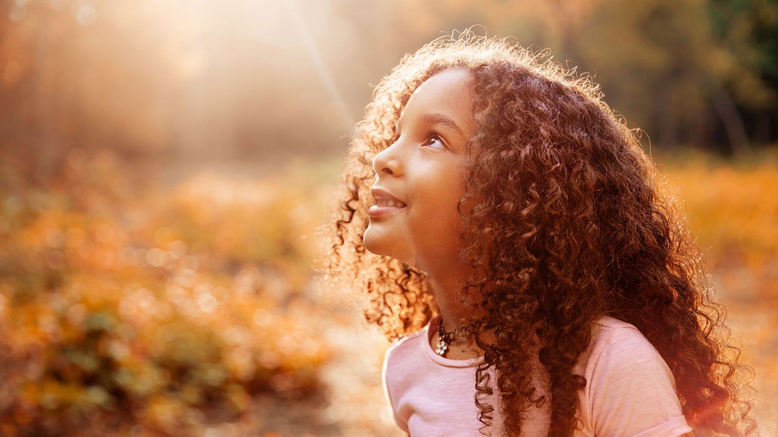 A smiling child gazes heavenward