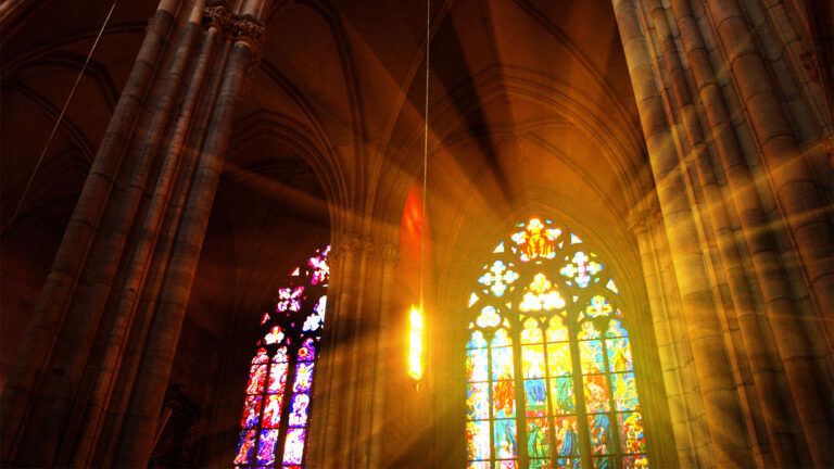 Church stained glass windows with sun rays shining through; Getty Images