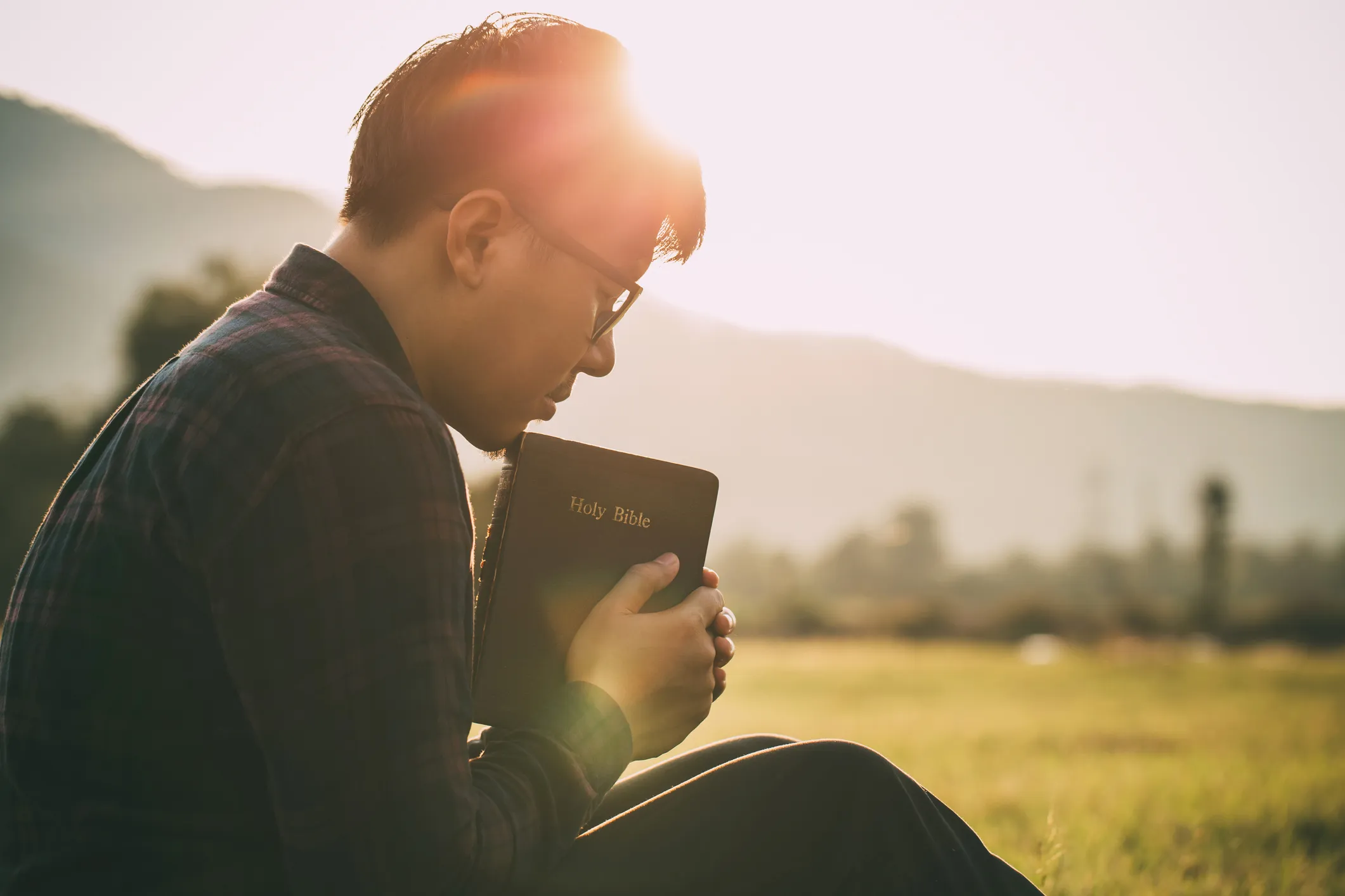 Man with Holy Bible in hand in deep prayer; Getty Images