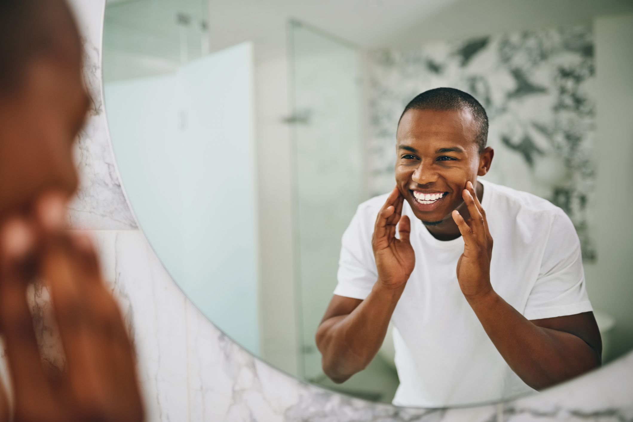 A man smiling in a mirror; Getty Images