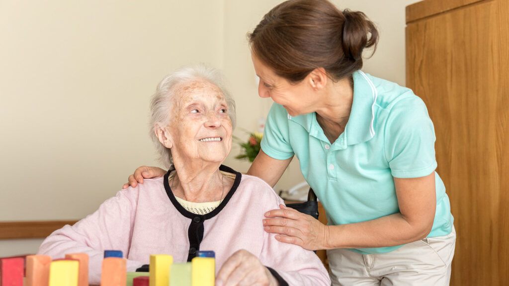 A caregiver assists a senior woman