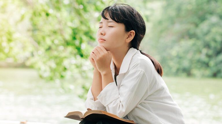 A woman prays outdoors