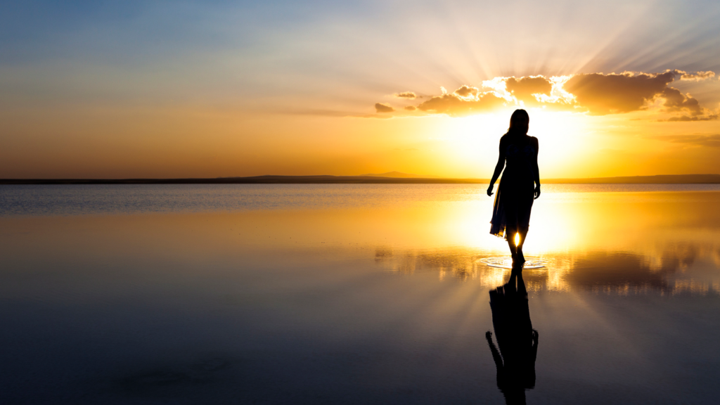 Silouette of woman walking into sunset light; Getty Images