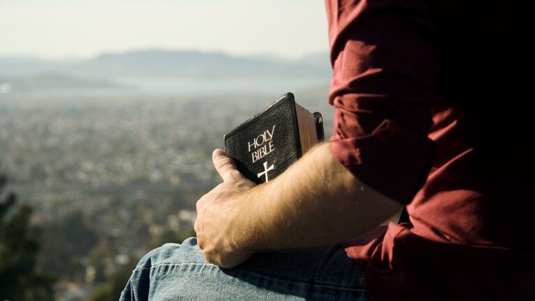 A man in the mountains with a Bible