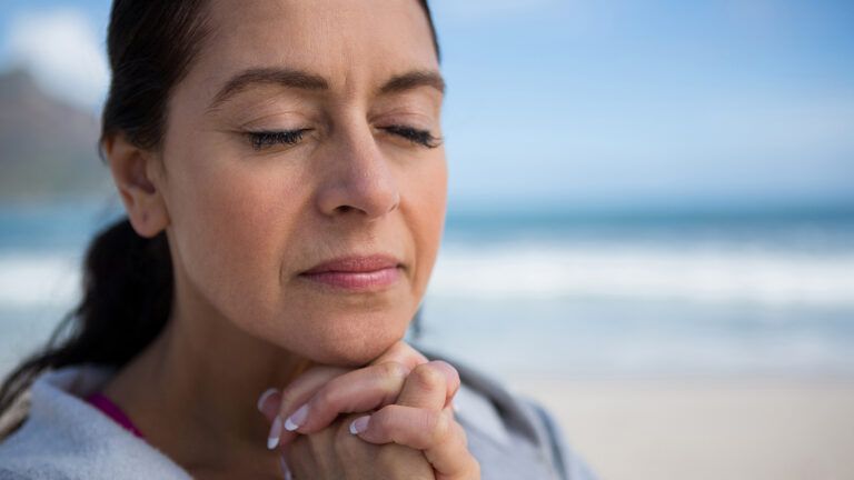 A woman prays at the beach
